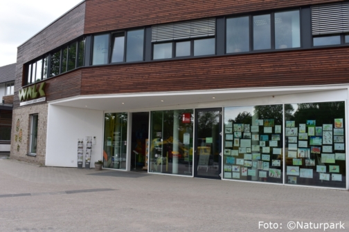 Foto des WALK Gebäude mit einer bunten Festerfront aus gemalten Bildern bei der Touristinformation