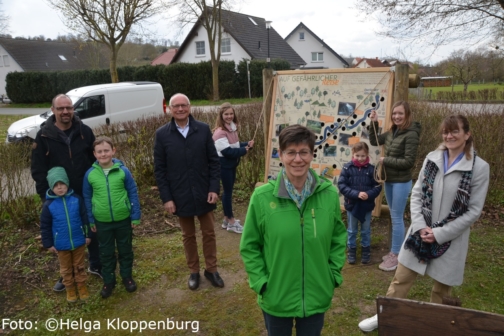 Die neuen Infoschilder an der lebendigen Altenau werden von Kindern und Erwachsenen aufgestellt.